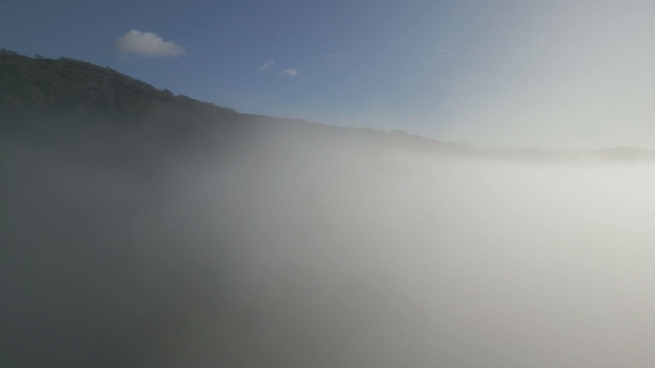 푸른 하늘과 흰 구름이 있는 화창한 가을 아침에 드론이 구름 역전을 통해 상승함에 따라 호수 지역의 드론 샷 상승