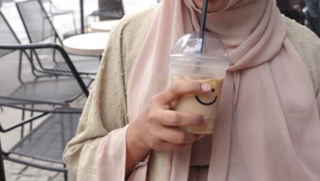 woman enjoying iced coffee in an outdoor cafe