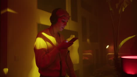 woman with headphones in a neon-lit studio