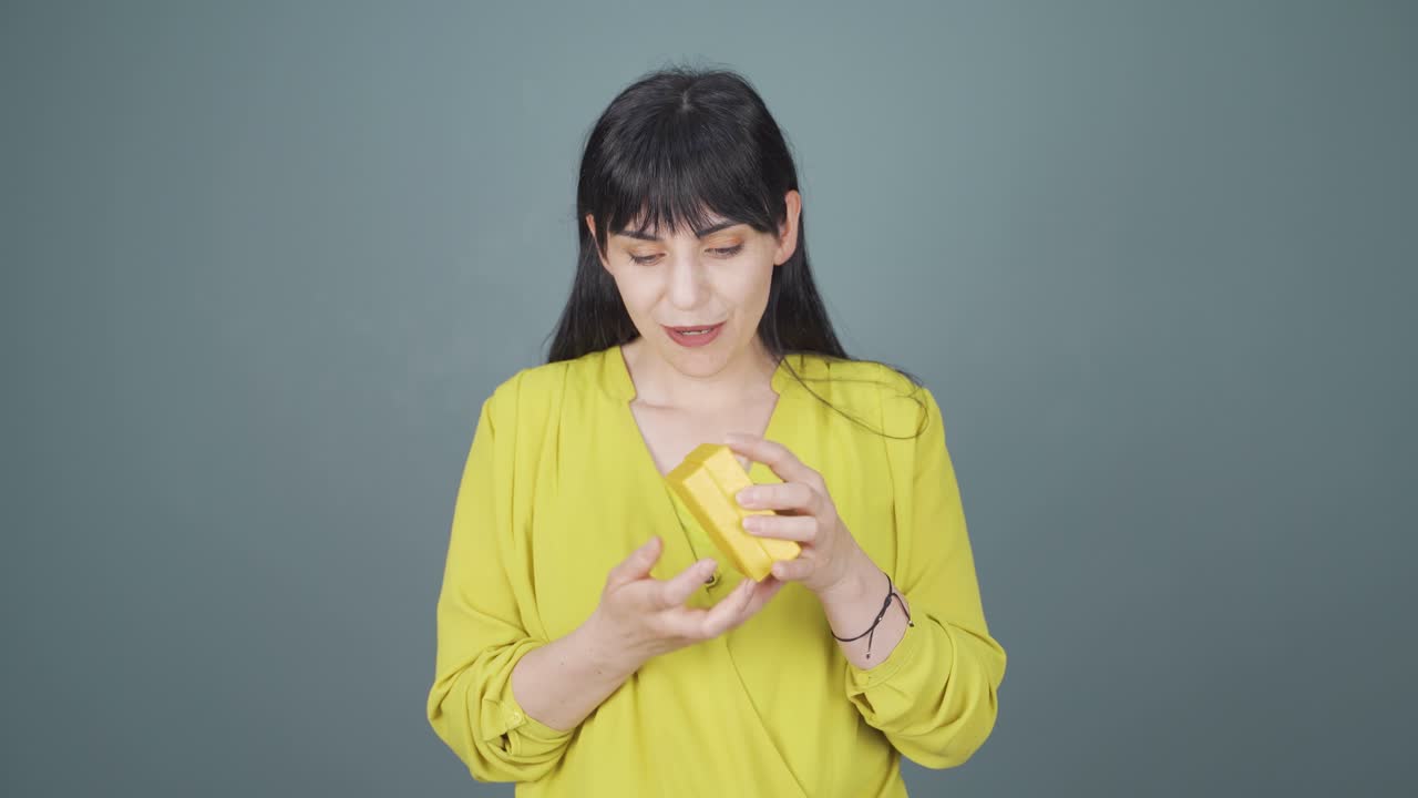 행복하고 즐거운 여자가 선물 패키지를 열고 있습니다.