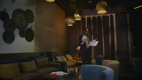 nervous business woman reading documents in office lounge at night