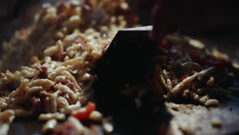 volviendo alrededor de la sartén de fideos de patata humeante con verduras usando spatuals