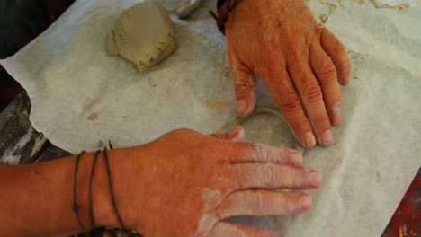 overhead of artist molding clay at table 4k