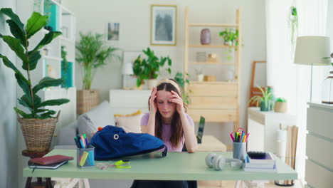 unhappy student unpacks her backpack and is sad