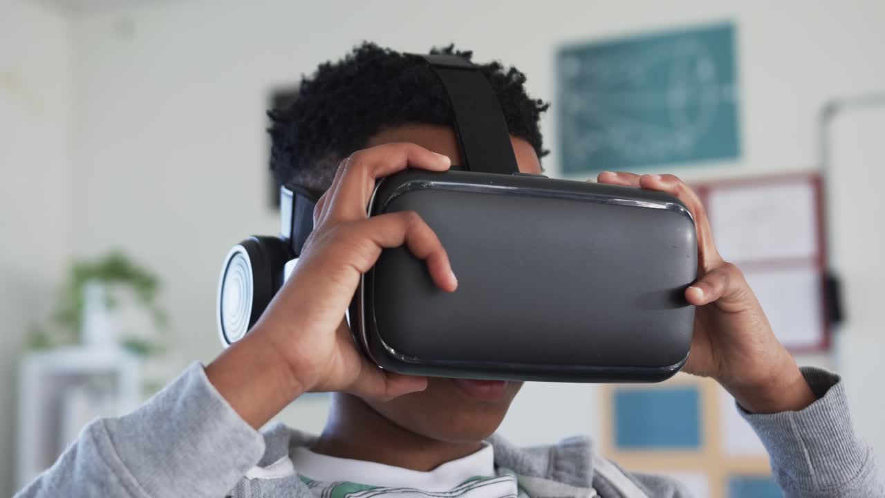 Barn trækker VR-visir ned fra panden og justerer remmen med høretelefoner for at starte undervisningen.