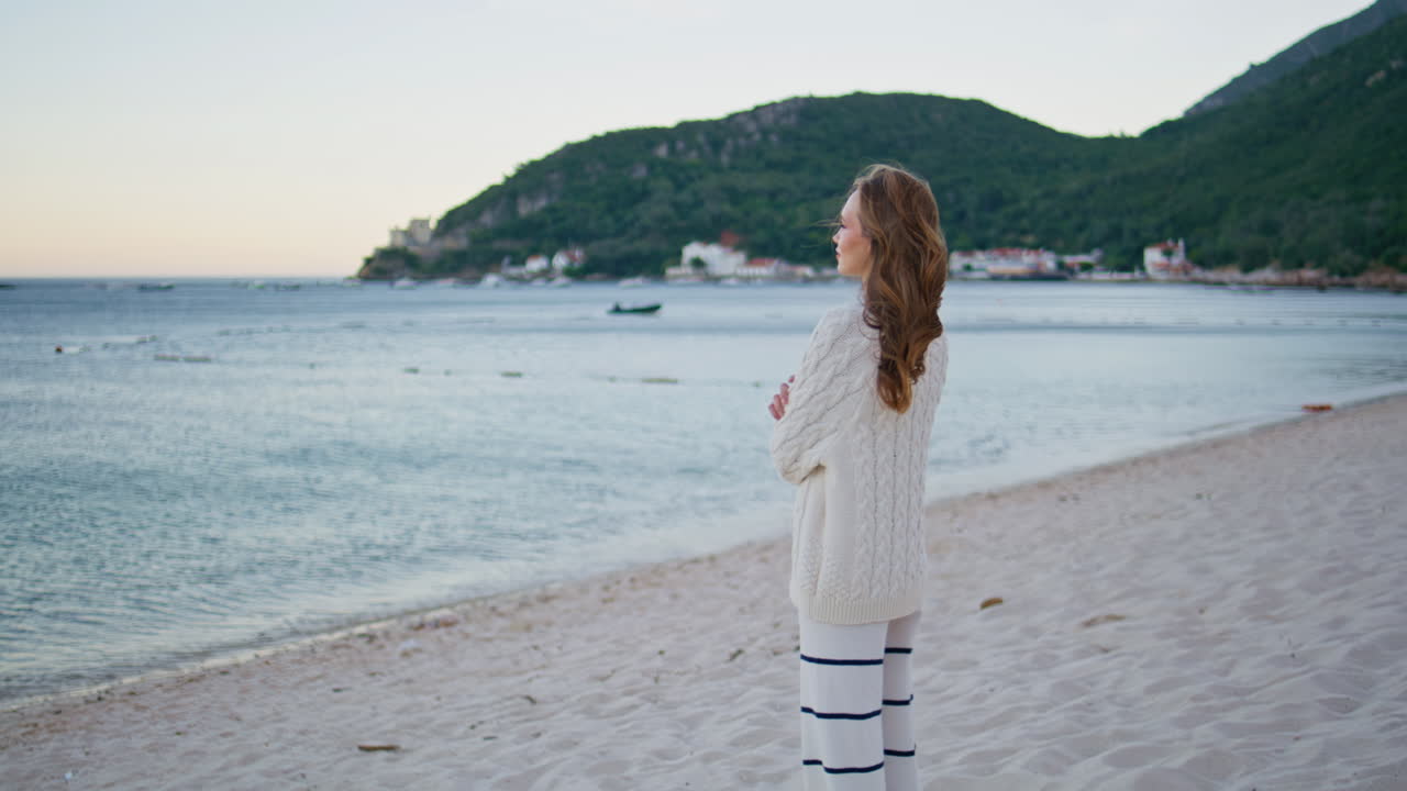 Girl enjoying evening seascape looking on marine horizon. Woman contemplating