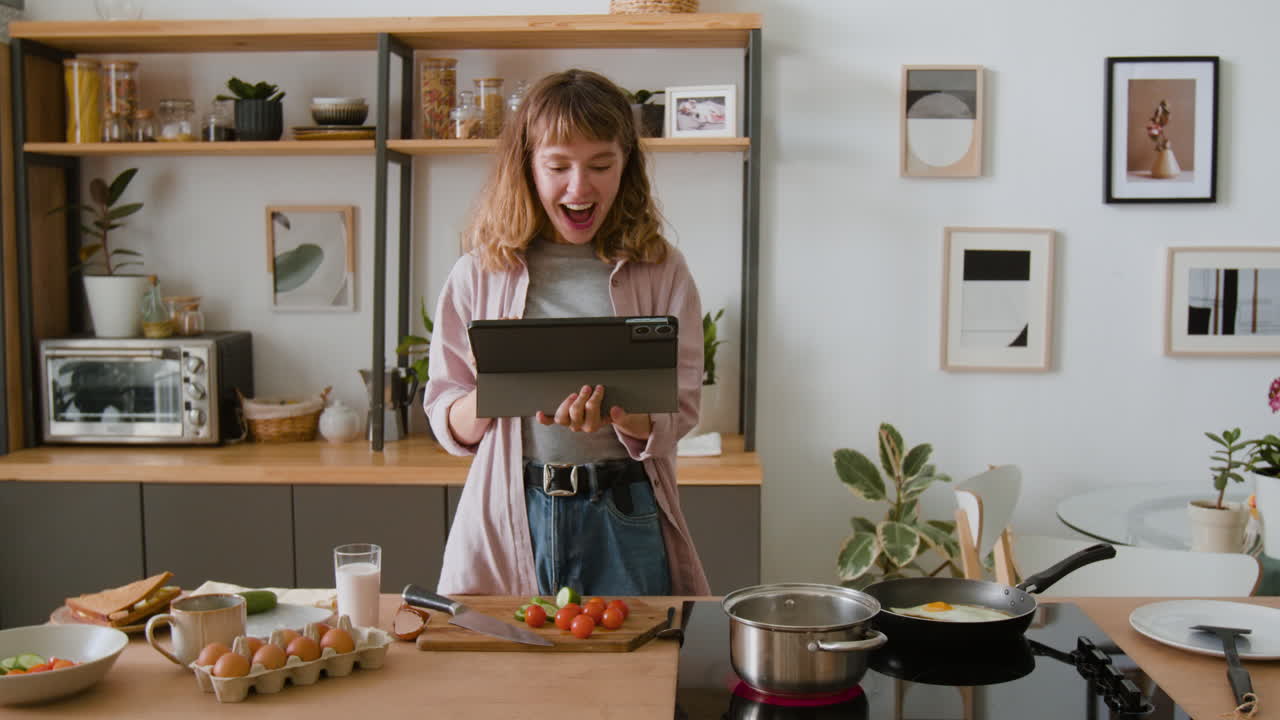 Woman cooking in the kitchen using a tablet