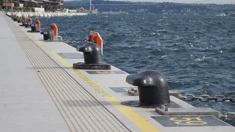 a dock with a line of bollards and a chain running along the edge