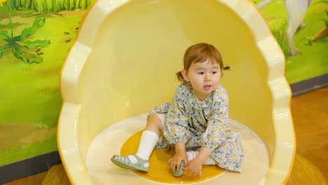 Cute-And-Pretty-Little-Girl-Sitting-On-Cracked-Egg-Shell-like-Chair-At-Gyeonggi-Children's-Museum-In-South-Korea