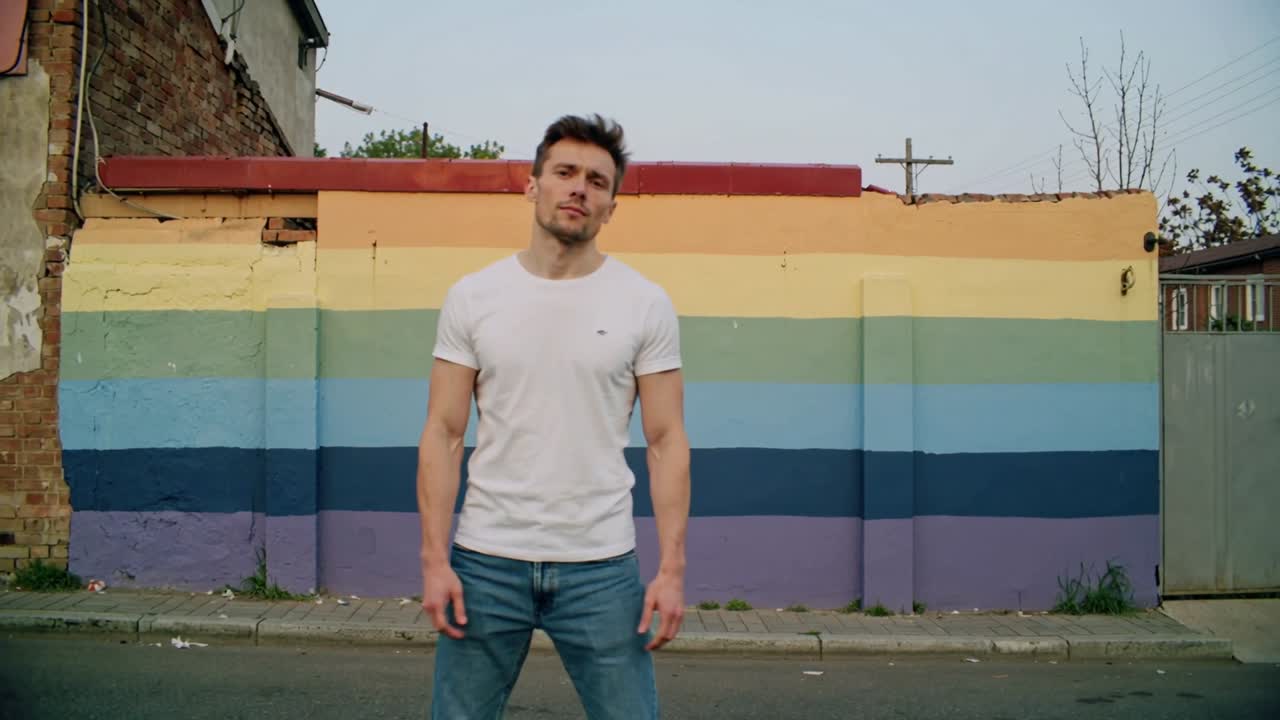 Camera tightening, animating lines over painted wall syncing with man shifting pose for fashion ad