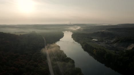 clouds and fogs obscure the vibrant sun over the calm waters of saint-francois river in windsor, quebec, canada