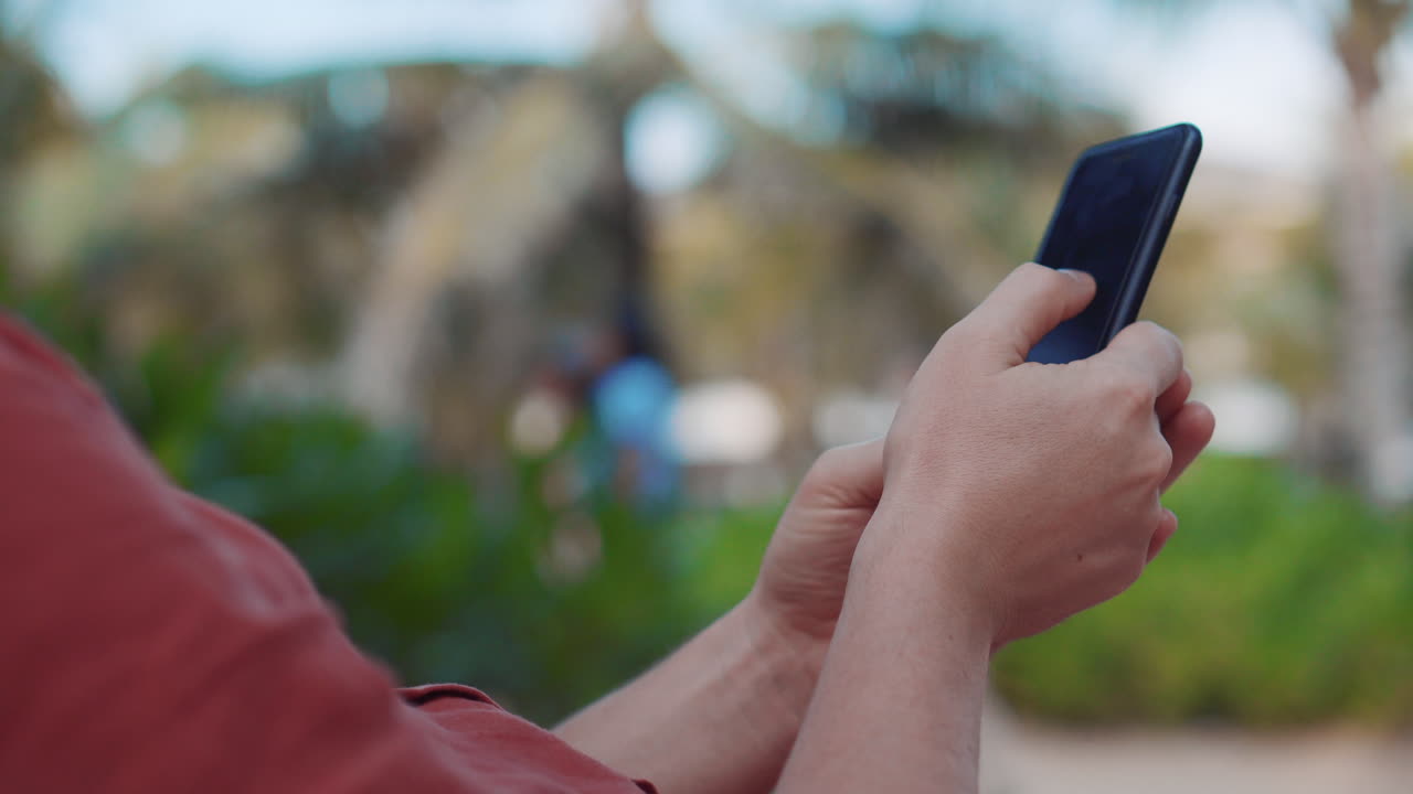 persona que utiliza un teléfono inteligente en un parque
