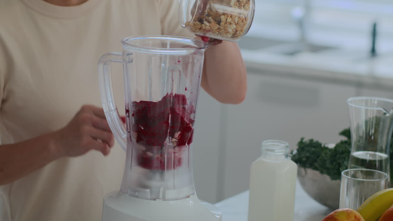 Unrecognizable Man Adding Nuts and Greenery to Dragon Fruit Smoothie