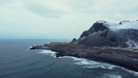 Mountain-slope-near-waving-sea