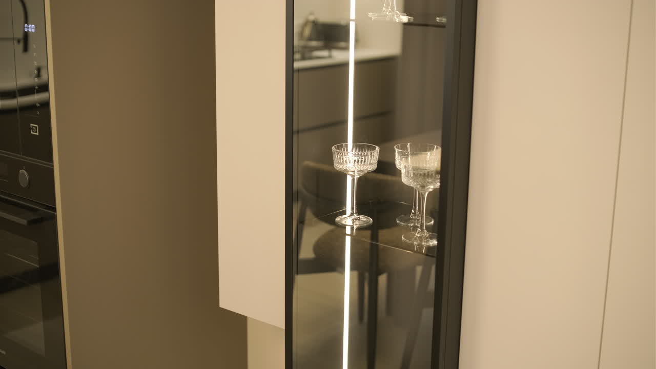 Cucina moderna con vetrinetta illuminata e calici da champagne