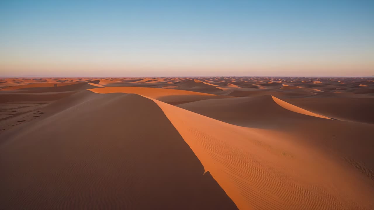 Drone che si solleva, angolazione della camera su una prominente cresta di dune di sabbia al tramonto, catturando motivi ondulati