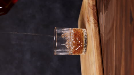 Whisky-Con-Hielo,-Mesa-De-Madera-De-Fondo-Oscuro