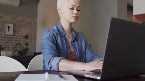 Mujer-Birracial-Ocupada-Trabajando-En-Casa-Con-Una-Computadora-Portátil-En-Cámara-Lenta