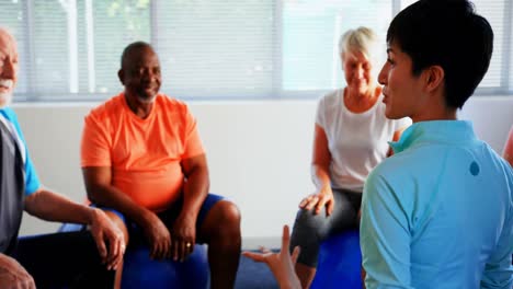 rear view of female trainer training senior people in the fitness studio 4k