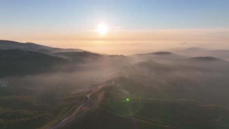 sunset in the countryside of portugal. forest covered hills and light fog at dusk. coimbra district - cantoneiros and cerdeira.