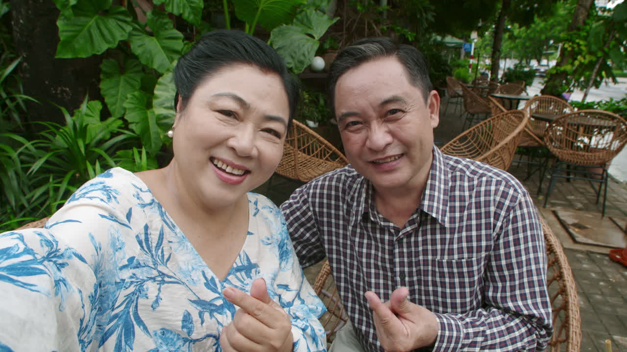 POV of Seniors Making Finger Heart Posing for Selfie