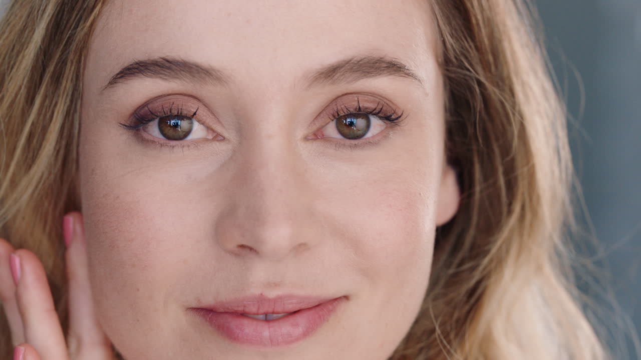 портрет красивой кавказской женщины, глядящей в зеркало на идеальную кожу, наслаждающейся естественной кожей, уверенно моргающей, готовящейся дома