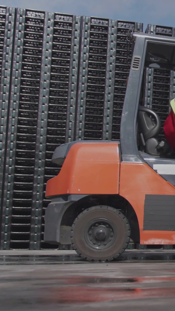 Vertikales Video: Gabelstaplerfahrer steigt zur Arbeit im Lager ein, Benachrichtigungen lösen Abo- und Glockensymbole aus.