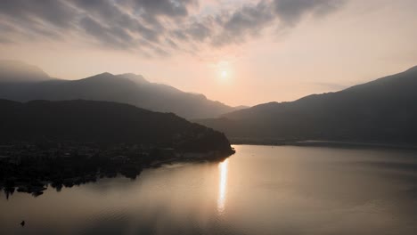 Vista-Aérea-Del-Amanecer-Sobre-El-Lago-De-Garda-Y-La-Ciudad-De-Riva-Del-Garda,-Norte-De-Italia