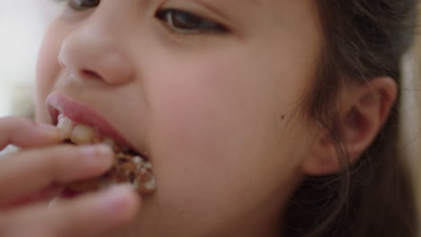 cerca de una niña feliz comiendo galletas sumergiendo galletas en chocolate caliente disfrutando de una deliciosa golosina en casa en la cocina