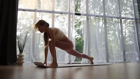 woman practicing yoga poses by the window