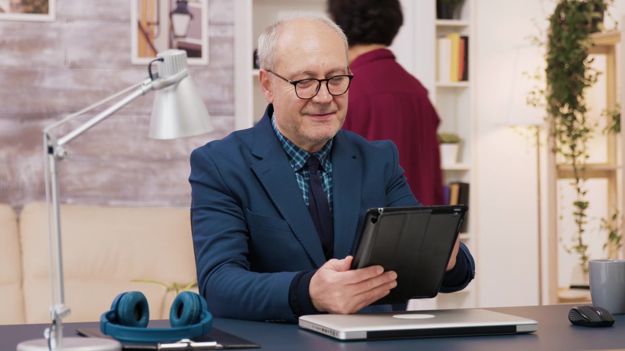 Moden forretningsmand bruger en tablet på et hjemmekontor