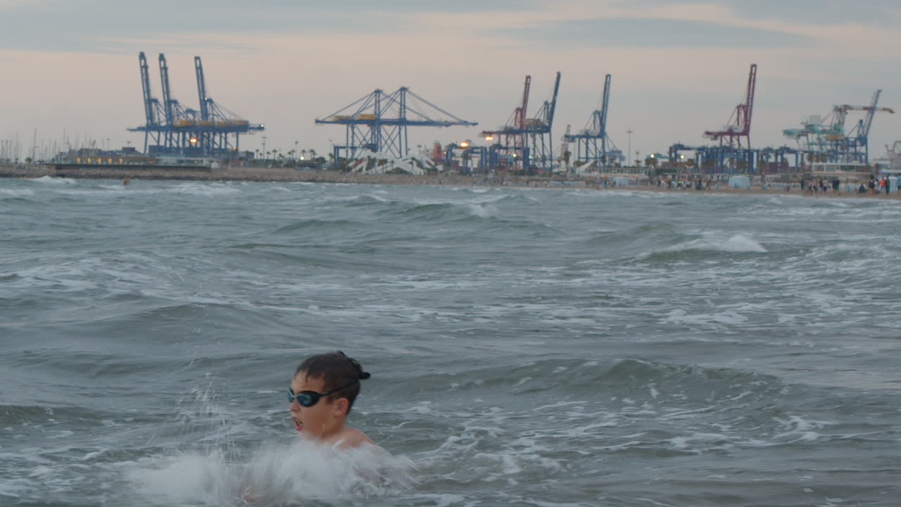 niño divirtiéndose con las olas del mar
