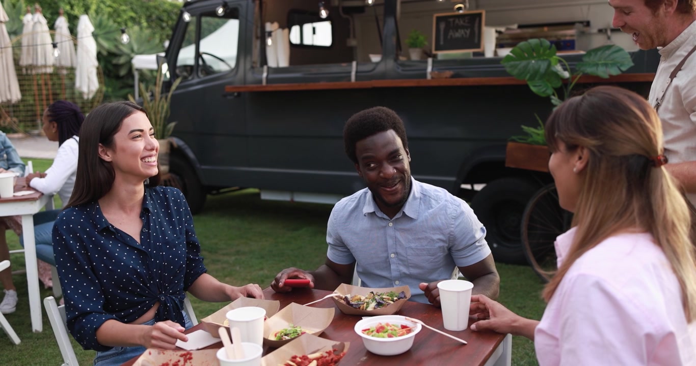 Happy Multi-Ethnic Friends Enjoying Food and Conversation at Outdoor Food Truck