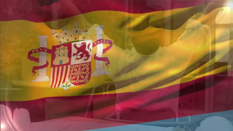 animation of flag of spain waving over smiling caucasian male architect stretching at desk