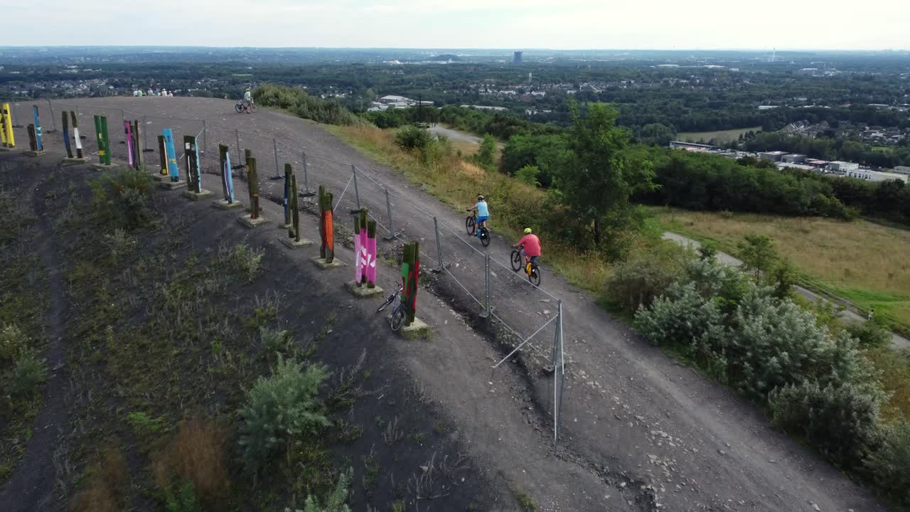 Cyclists on a scenic hill with artwork