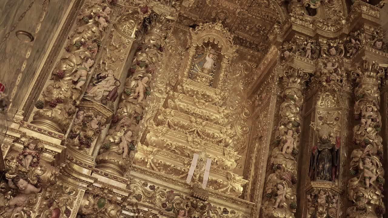 Altare barocco dorato e intarsiato con intagli dettagliati e sculture religiose