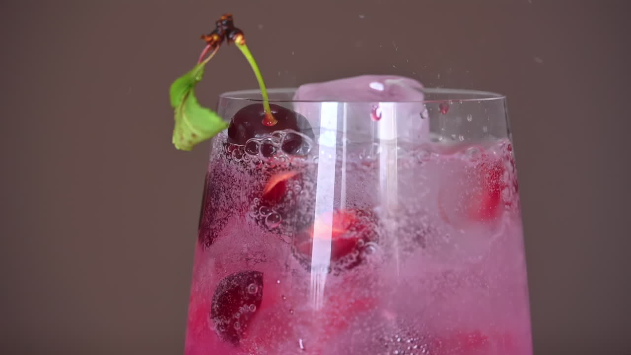 Primer plano a cámara lenta de soda vertiéndose en un cóctel de verano de fresas congeladas con hielo y ron