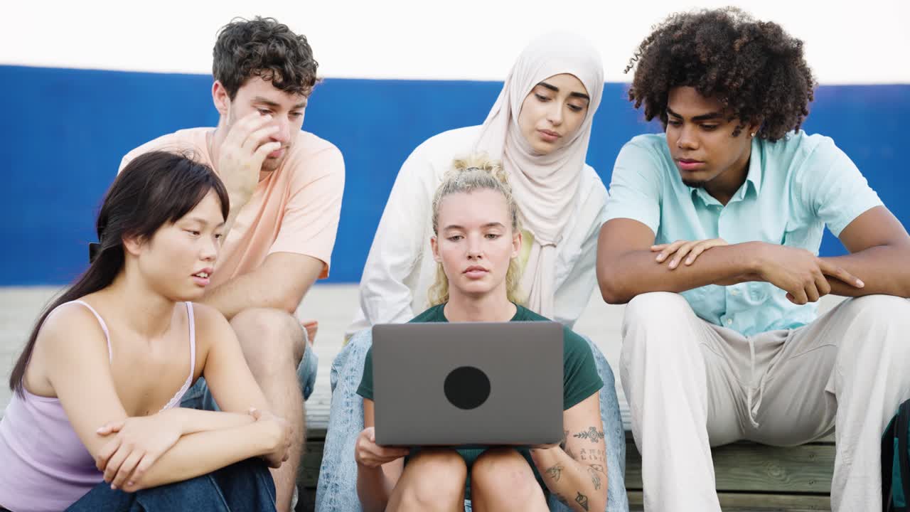Sekelompok anak muda yang beragam bereaksi terhadap konten laptop