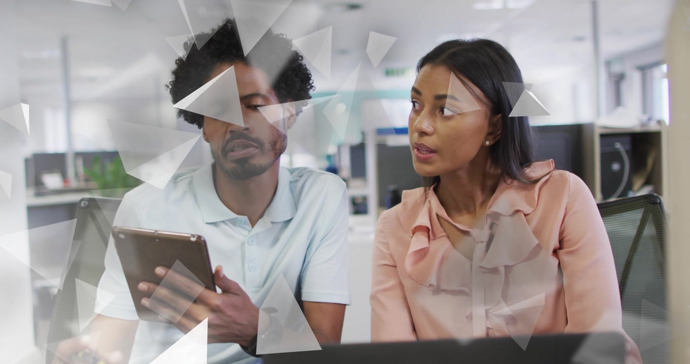 Man tapping tablet in office causing faint triangles overlaying, peer following taps reviewing data