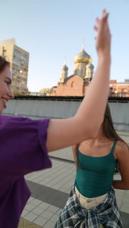 dos mujeres hablando al aire libre en una plaza de la ciudad