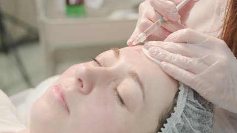 woman undergoing facial treatment at cosmetologist clinic