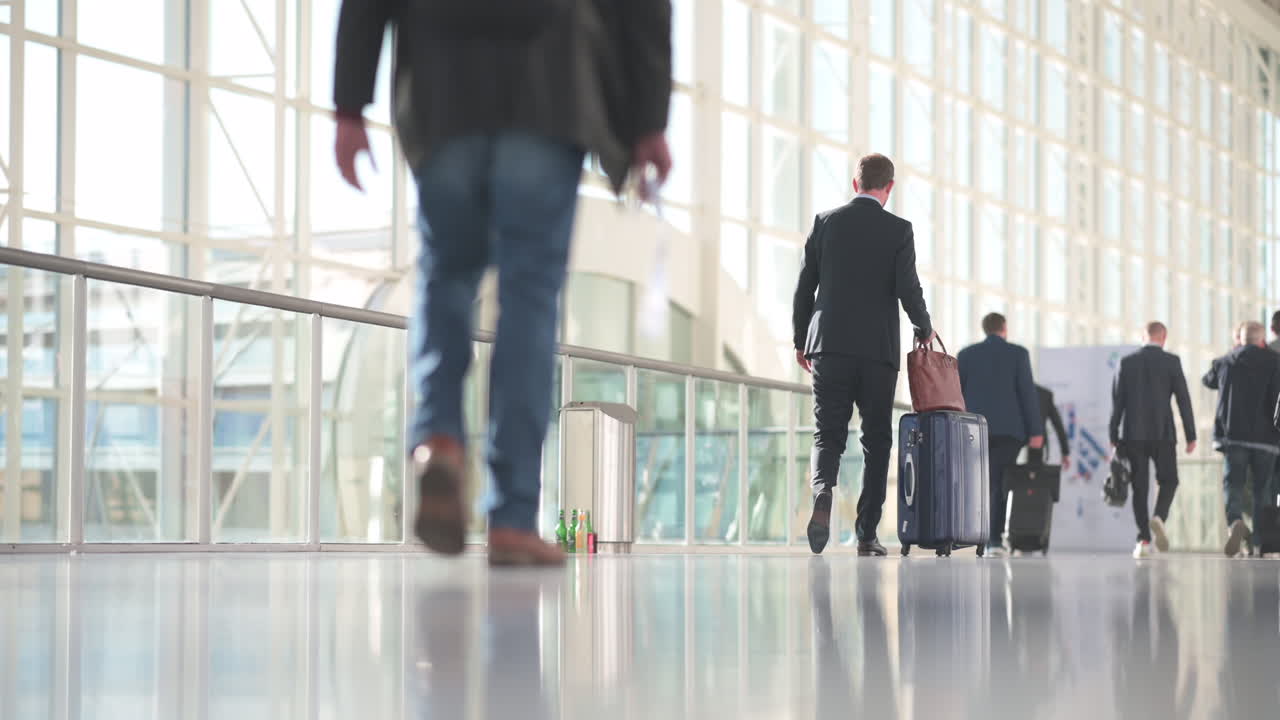 hombre de traje caminando con carrito en un salón luminoso