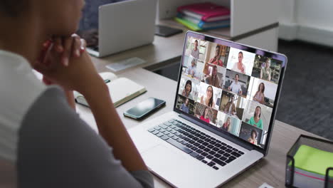 mujer afroamericana teniendo una videoconferencia en una computadora portátil con colegas de oficina en la oficina