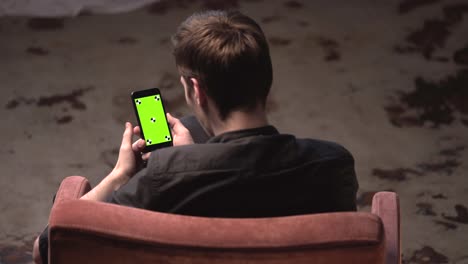 man using a smartphone with a green screen