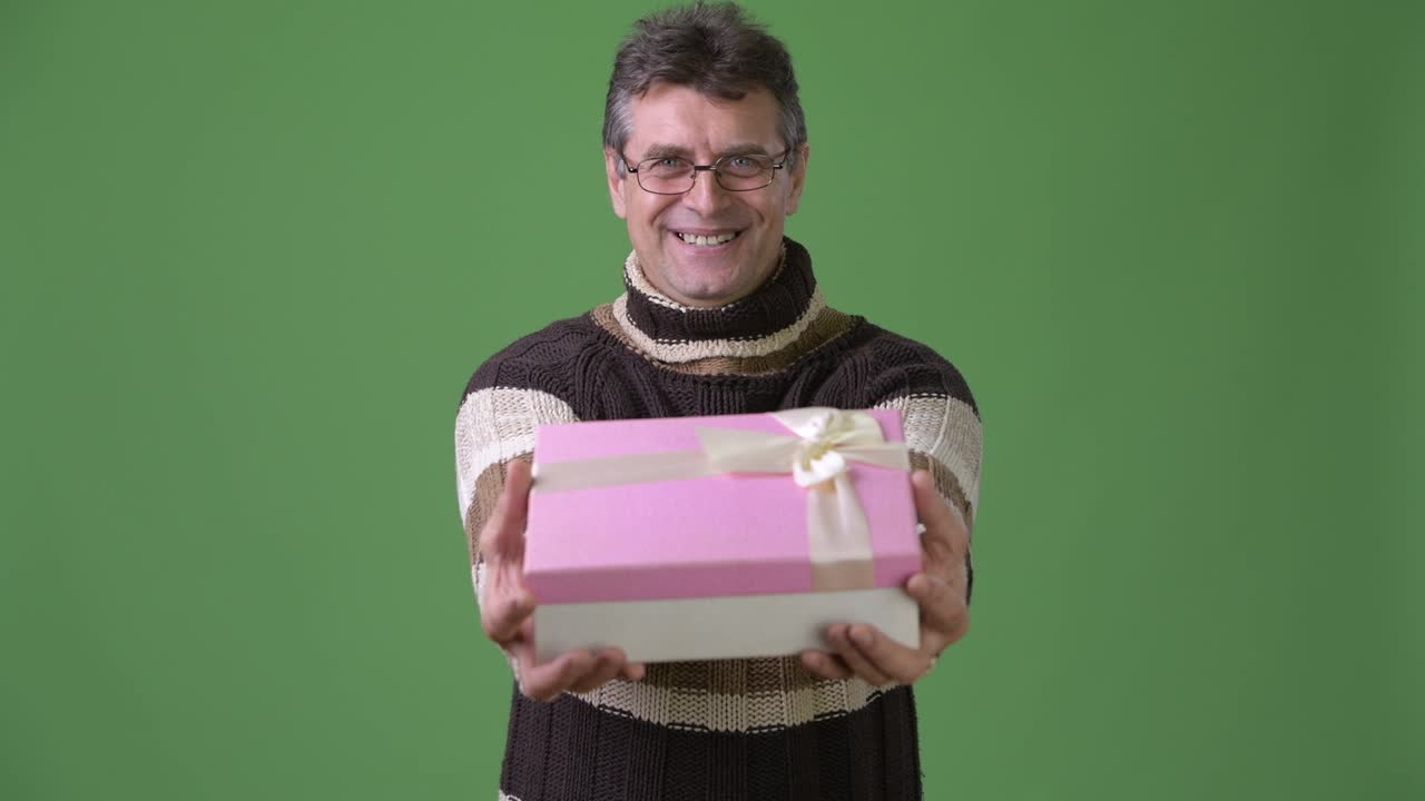 초록색 배경 에 털 목 스웨터 를 입은 성숙 한 잘생긴 남자