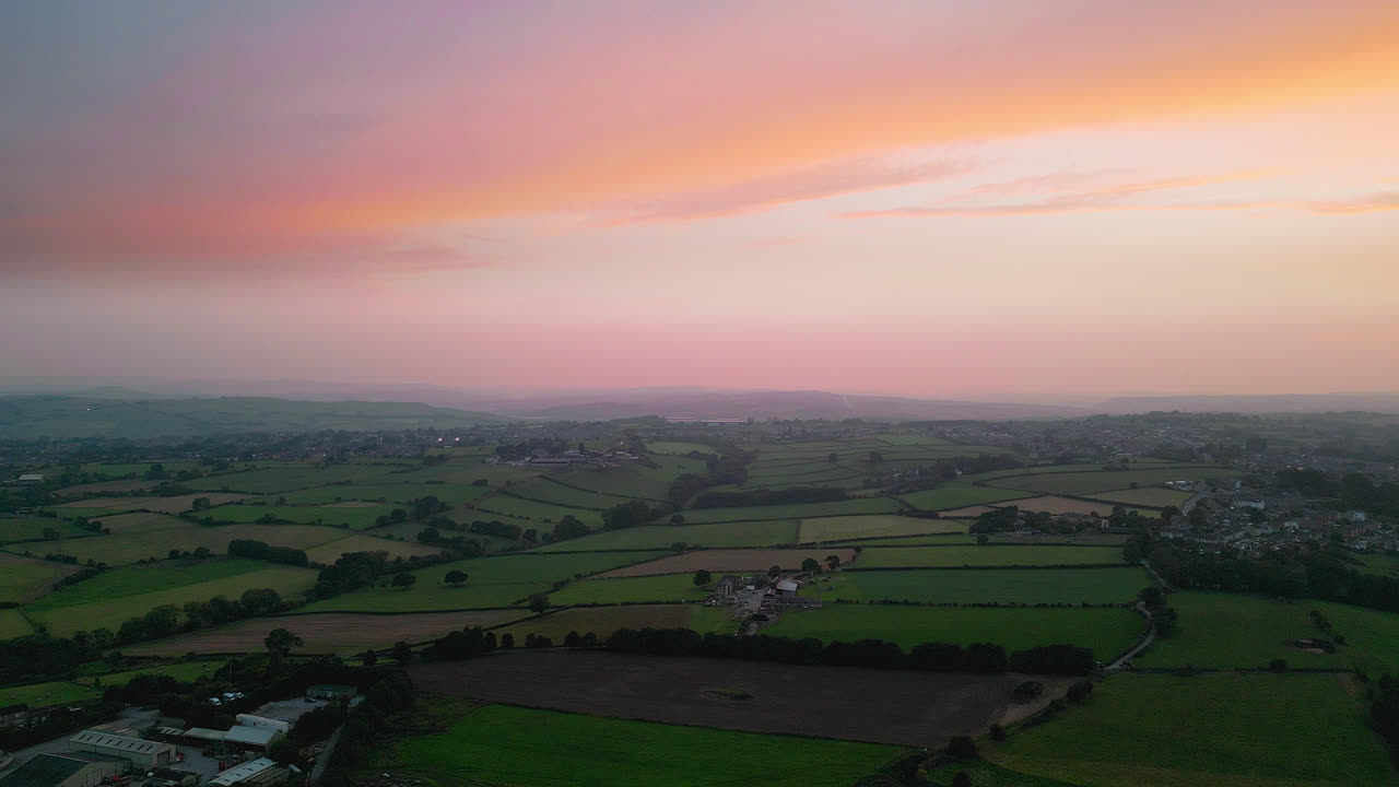 영국 헤크몬드와이크 를 체험 하십시오. 드론 으로 촬영 된 매혹적 인 공중 영상 을 통해, 여름 저녁 에 산업 구조물, 활기찬 거리, 그리고 역사적 인 도시 중심지 를 강조 합니다.