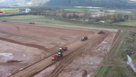 tractors with trailers moving soil on a construction site