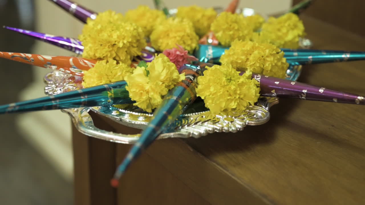 Henna cones on silver tray with yellow flowers. Indian Wedding rituals.