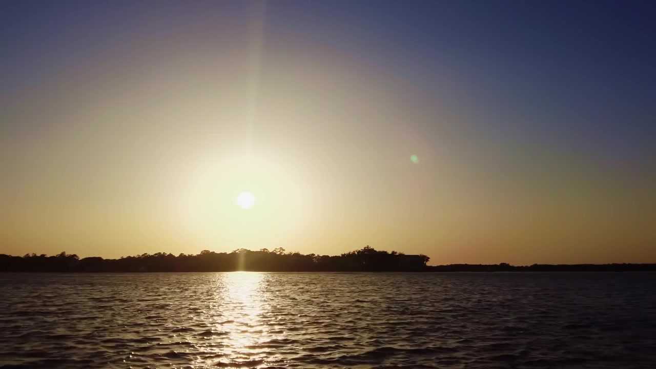 Sun setting over the sound or large body of water