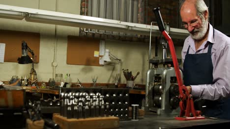 goldsmith working on machine in workshop 4k